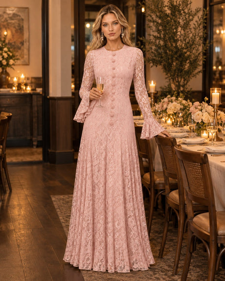 Wedding guest in a blush-pink lace gown standing in a warmly lit private dining room