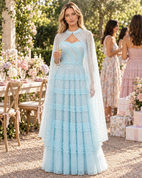 Bridal-shower guest in a light-blue tiered cape maxi dress at a garden brunch
