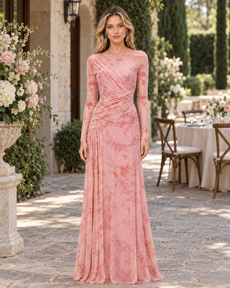 Wedding guest in a pink floral mesh long-sleeve maxi dress in a garden courtyard.